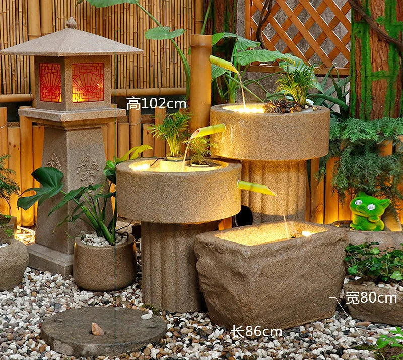Outdoor decorative fountain with stone lantern and plants in a garden setting
